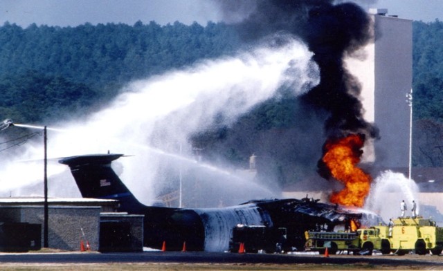 Firefighters spray foam and water on a burning C-141 aircraft that burst into flames at Green Ramp on Pope Air Force Base, March 23, 1994. The C-141 was set ablaze after it was struck by an F-16 that collided in mid air with a C-130H aircraft.