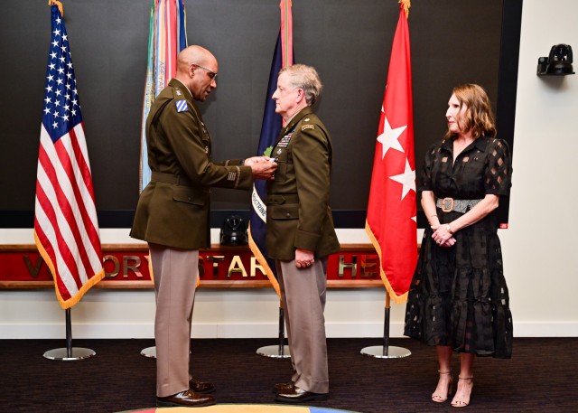 Gen. Gary Brito, commanding general, U.S. Army Training and Doctrine Command, presents retired Army Maj. Larry Moores with the Silver Star during a ceremony in front of family and friends March 25. Moores&#39; wife, Retired Army Col. Kerry E. Moores, watches the presentation. 