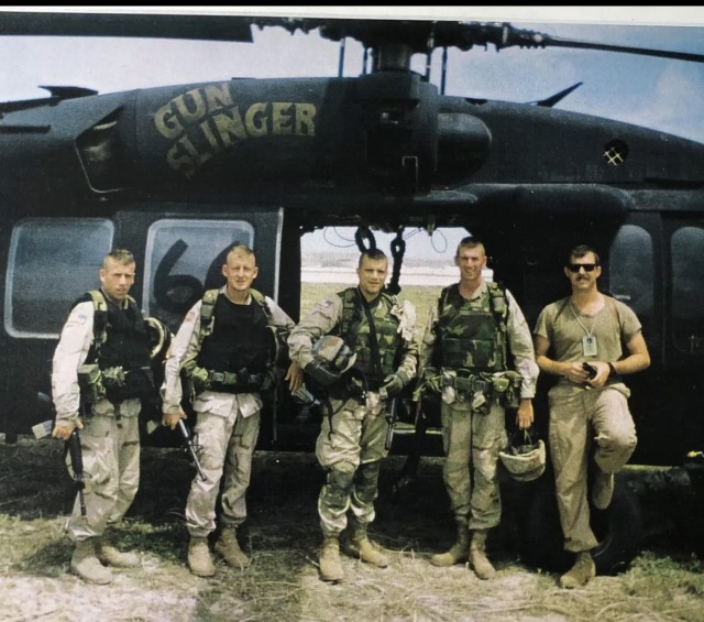 Retired Army Maj. Larry Moores (second from left) is shown with leaders in front of Gunslinger and pilot from TF 160.   
