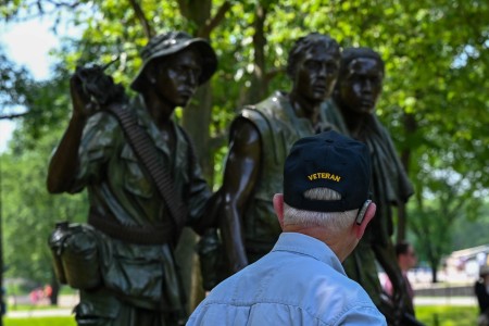 A veteran visits the Three Serviceman Statue, a statue of three Vietnam War Soldiers gazing toward the Memorial Wall of the Vietnam Veterans in Washington, D.C, March 20, 2024. Part of the Vietnam Veterans Memorial, the statue honors those who fought and returned from the war by showing them standing, keeping watch over the wall. The memorial is the most visited memorial on the Washington, D.C. Mall with more than 5 million visitors every year.