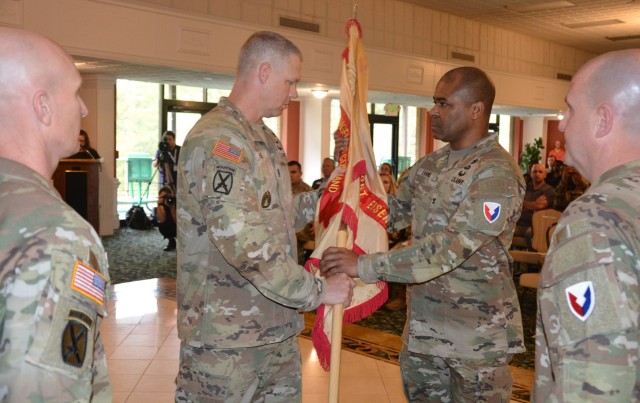 U.S. Army Garrison Eisenhower Command Sgt. Maj. Aaron J. Rose passes the unit colors to Eisenhower Garrison Commander Col. Reginald K. Evans, April 2, in the Fort Eisenhower Conference Center. This ceremony, a time-honored tradition that commemorates the symbolic relinquishment of responsibility and leadership from one senior noncommissioned officer to another, by the passing of the organizational colors.  