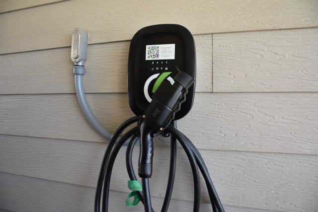 A Level 2 electrical vehicle charger is mounted on the side of a house. 
