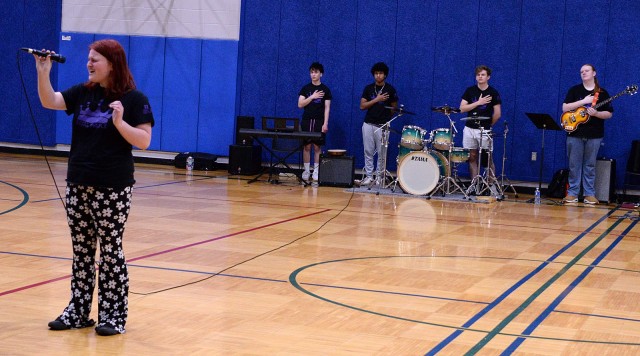 Royal Purple lead singer Alayna Parvin, Lansing High School graduate and freshman in music education at Baker University in Baldwin City, Kan., sings the national anthem as her bandmates Jonathan Duncan, junior at Lansing High School; Darien...