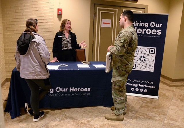 Staff Sgt. Rebekah Widmann and Sgt. Miguel Osasio, both of Army Corrections Brigade, talk with Jamie Webb, Hiring Our Heroes Corporate Fellowship Program manager, during the Career and Education Fair April 2 at the Frontier Conference Center at...