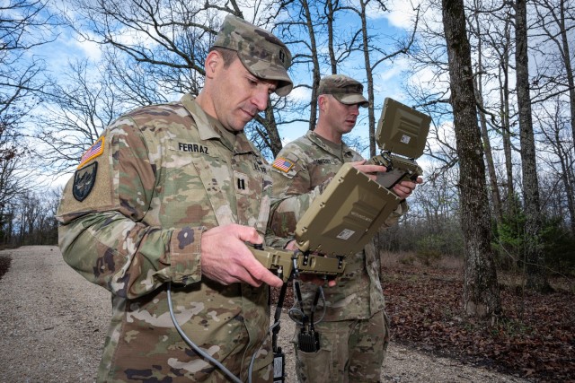 Capt. Brandon Ferraz, 1st Engineer Brigade Headquarters and Headquarters Company commander, and Staff Sgt. Gary Coggins, a drill sergeant for Company D, 31st Engineer Battalion, practice operating a robot April 3 at Training Area 401 in...