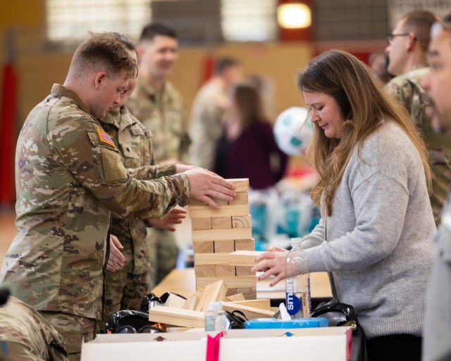Soldiers and a participant playing Jenga at one of several informational booths during U.S. Army Garrison Rheinland Pfalz's Volksmarch at the Baumholder Hall of Champions on Smith Barracks, April 3, to raise awareness for Sexual Assault...
