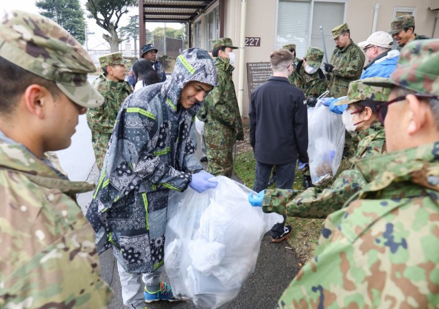 Sgt. Shawn Rosario, center, a member of the Better Opportunities for Single Soldiers program, collects trash during a cleanup event at Camp Zama, Japan, April 3, 2024. Rosario and other Soldiers also volunteered to host a friendly competition with local Japanese children following the cleanup.