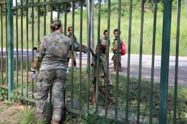 U.S. Air Force Staff Sgt. Victoria Wickersheim, of the Wisconsin National Guard’s 115th Security Forces Squadron, greets Papua New Guinea children during a break from security training March 18, 2024, as part of a visit by 40 Wisconsin National Guard members to Papua New Guinea in support of the State Partnership Program. The Wisconsin National Guard and Papua New Guinea began their partnership in 2020.