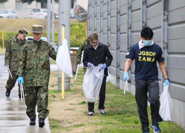 Members of the Better Opportunities for Single Soldiers program and Japan Ground Self-Defense Force partners pick up trash near Gate 4 at Camp Zama, Japan, as part of a cleanup event April 3, 2024. The Soldiers also volunteered to host a friendly competition with local Japanese children following the cleanup. 