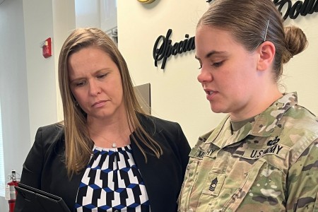 Jennifer Smith, Special Victim Liaison program director, discusses dates for upcoming court-martials with Master Sgt. Margaret Murphy at the Army Office of Special Trial Counsel headquarters, Fort Belvoir, Virginia, March 14, 2024. 