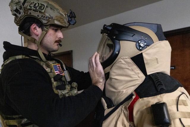 U.S. Air Force Airman 1st Class Robert Wittig, left, closes the helmet on Senior Airman Russell J. Bongiovanni’s EOD-10E bomb suit. The explosive ordnance disposal technicians with the 177th Fighter Wing, New Jersey Air National Guard, were participating in the Joint Chemical, Biological, Radiological, Nuclear, and High Yield Explosives Characterization, Exploitation, and Mitigation Course at the CURE Insurance Arena in Trenton, New Jersey, March 27, 2024. (New Jersey National Guard photo by Mark C. Olsen)