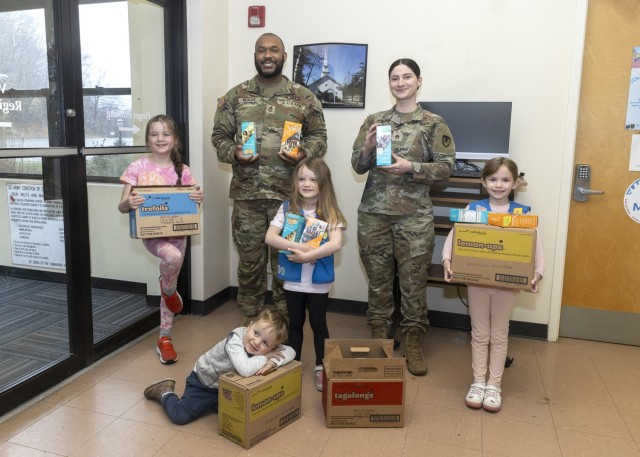 PICATINNY ARSENAL, N.J. - Staff Sgt. Randy McKire Jr., and Staff Sgt. Jacqueline Whimple, receive cookies from representatives of Girl Scout Troop 98861.