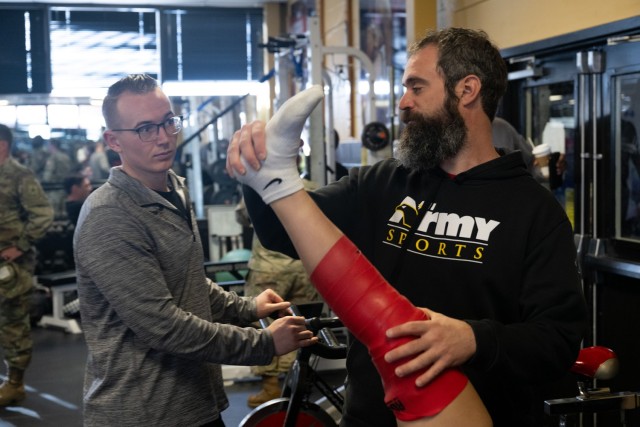 Members of the High Performance Team Kyle Ekert, head athletic trainer, and Sgt. Cody Smith, healthcare specialist, work on an athlete during a workout for the Army WorldClass Athlete Program gym in Fort Carson, Colo. March 11, 2024.