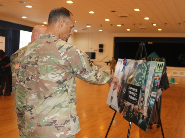 Maj. Gen. Robert L. Edmonson II, APG senior commander and commanding general of the U.S. Army Communications-Electronics Command and CECOM Command Sgt. Maj. Michael Conaty views a SAAPM poster.