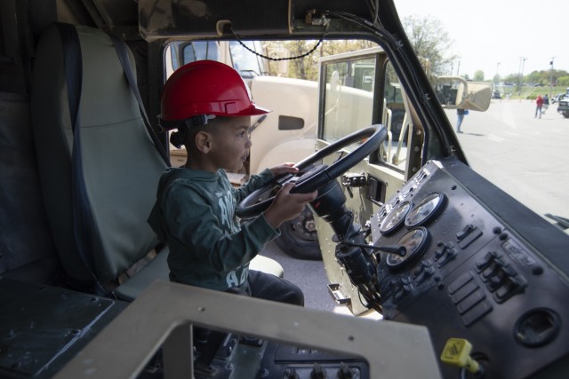 Three-year-old Isaias Burnett gets a look inside the cabin of a loading handling system vehicle April 20 in the Gerlach Field parking lot during one of the installation’s largest Month of the Military Child events, MOMC-Palooza.