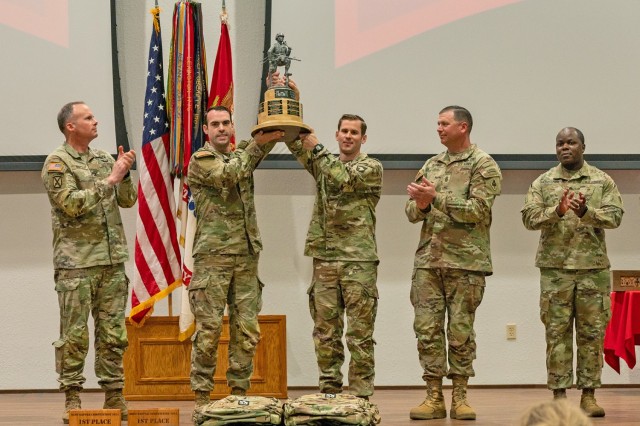The winners of the 17th Lt. Gen. Robert B. Flowers Best Sapper Competition, Capts. Matthew Cushing and Joseph Palazini, from the 101st Airborne Division at Fort Campbell, Kentucky, hold up their trophy as Col. Joseph Goetz, U.S. Army Engineer School commandant (left), USAES Regimental Command Sgt. Maj. Zachary Plummer (second from right) and USAES Regimental Chief Warrant Officer 5 Willie Gadsden look on, during the 2024 Best Sapper Competition awards ceremony April 23, 2024 at Nutter Field House. 