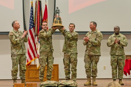 The winners of the 17th Lt. Gen. Robert B. Flowers Best Sapper Competition, Capts. Matthew Cushing and Joseph Palazini, from the 101st Airborne Division at Fort Campbell, Kentucky, hold up their trophy as Col. Joseph Goetz, U.S. Army Engineer School commandant (left), USAES Regimental Command Sgt. Maj. Zachary Plummer (second from right) and USAES Regimental Chief Warrant Officer 5 Willie Gadsden look on, during the 2024 Best Sapper Competition awards ceremony April 23, 2024 at Nutter Field House. 