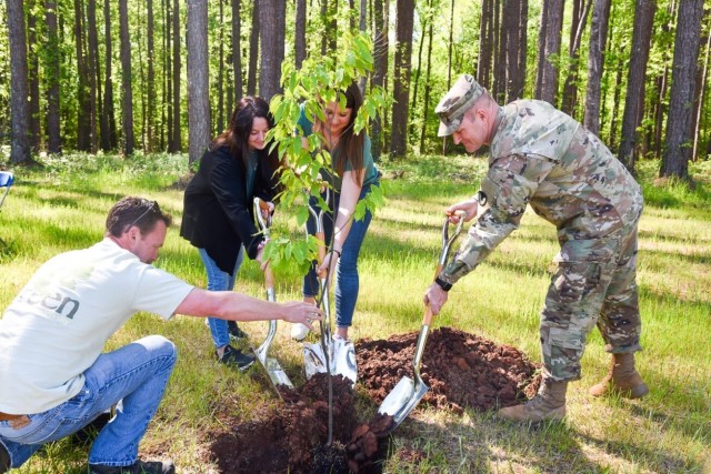 From Left, Greg Hicks, Lauren Zimmermann, Allison Guilliams, and Garrison Commander Col. Brian Cozine plant a tree at the Outdoor Learning Center.