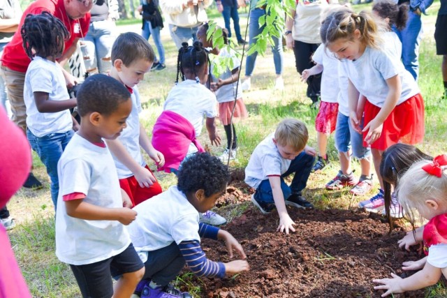 Students from the Goss Road Child Development Center add dirt to cover the newly planted tree in honor of Arbor Day during the Earth Day celebration Thursday.