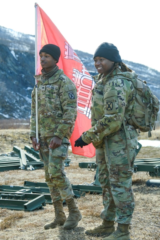 BJERKVIK, Norway (April 26, 2024) - U.S. Army Spc. Damon Daniels, left, and 1st Lt. Kourtney Scott, both assigned to 3rd Brigade Combat Team, 10th Mountain Division, carry a U.S. Army Corps of Engineers flag during a medium girder bridge exercise in support of Immediate Response 2024 in Bjerkvik, Nordland County, Norway, April 26, 2024. DEFENDER is the Dynamic Employment of Forces to Europe for NATO Deterrence and Enhanced Readiness, and is a U.S. European Command scheduled, U.S. Army Europe and Africa conducted exercise that consists of Saber Strike, Immediate Response, and Swift Response. DEFENDER 24 is linked to NATO’s Steadfast Defender exercise, and DoD’s Large Scale Global Exercise, taking place from 28 March to 31 May. DEFENDER 24 is the largest U.S. Army exercise in Europe and includes more than 17,000 U.S. and 23,000 multinational service members from more than 20 Allied and partner nations, including Croatia, Czechia, Denmark, Estonia, Finland, France, Germany, Georgia, Hungary, Italy, Latvia, Lithuania, Moldova, Netherlands, North Macedonia, Norway, Poland, Romania, Slovakia, Spain, Sweden, and the United Kingdom. (U.S. Navy photo by Mass Communication Specialist 2nd Class James S. Hong)