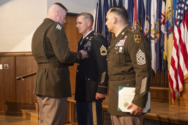 At an April 29 ceremony in Lincoln Hall Auditorium, Maj. Gen. Christopher Beck, Maneuver Support Center of Excellence and Fort Leonard Wood commanding general (left), and MSCoE and Fort Leonard Wood Command Sgt. Maj. Jorge Arzabala (right) present the Soldier’s Medal to Sgt. 1st Class Matthew Mobley for life-saving actions, when a motorist was trapped in a burning car in January 2021, in Crocker, Missouri. Mobley, who just completed the Army’s Career Skills Program, is set to retire May 31.