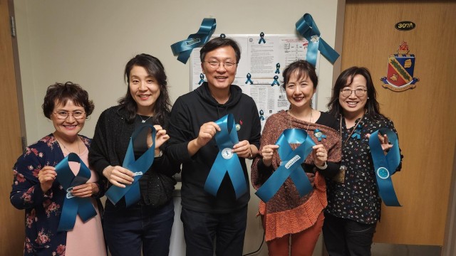 Members of the the Korean LTD at Osan Air Base, South Korea, show off their teal ribbons for Sexual Assault Awareness and Prevention Month.