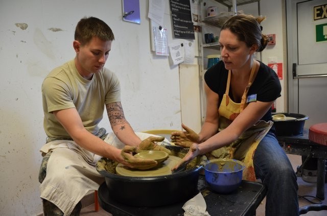 Michelle Sterkowicz, Supervisory Arts Specialist, shows Spc. Kevin Taylor, how to use the pottery wheel during Resiliency through Art class at the Vicenza Family and MWR Arts and Crafts Center. (File photo)