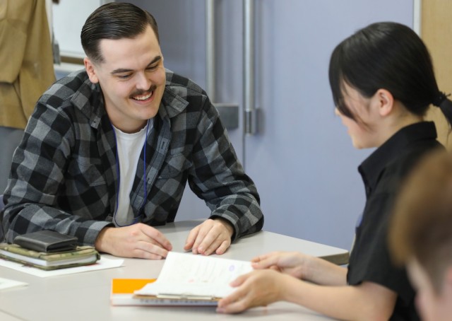 Staff Sgt. Brian Hanson, assigned to the 38th Air Defense Artillery Brigade, speaks with a Japanese student during a language and cultural event at Zama City Hall, Japan, May 3, 2024. The volunteers helped a group of students get ready for an...