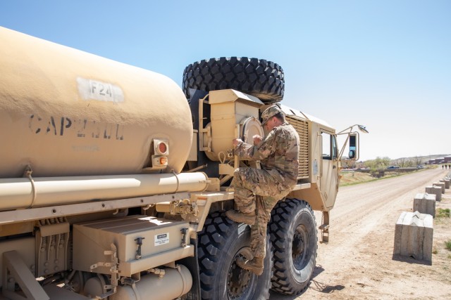 Sgt. Nicolas Arellano, a wheeled vehicle mechanic assigned to Headquarters and Support Company, Headquarters and Headquarters Battalion, 4th Infantry Division, climbs down from a Heavy Expanded Mobility Tactical Truck Fuel Servicing Truck after stowing a grounding rod during Ivy Sting 3 at Fort Carson, Colorado, April 24, 2024. Sustainment operations like fuel points are essential to mission success.