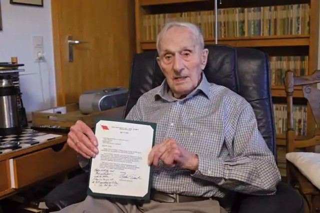 Charles Ferber holding his certificate and birthday card