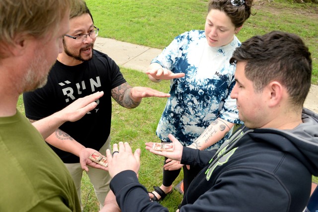 Nicole Harnisch, performance expert at the R2 Performance Center, instructs Sam Luy, Inmate Services Branch lead; Jamin Claassen, ISB clerk; and Sgt. Juan Sanchez, Headquarters and Headquarters Company, Midwest Joint Regional Correctional Facility...