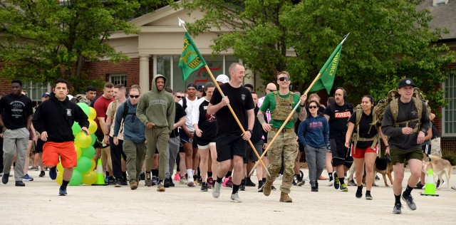 Guidon bearers Sgt. Daniel Hepburn, Headquarters and Headquarters Company, Midwest Joint Regional Correctional Facility Battalion (Corrections), and Staff Sgt. Andrew Snyder, A Company, MWJRCF, lead participants from the starting point of the Army...