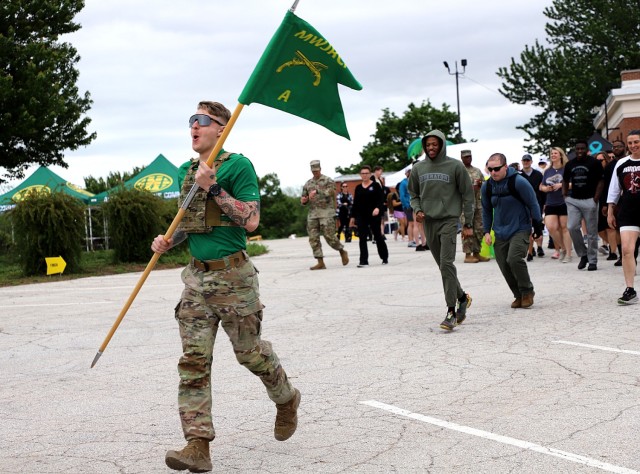 Staff Sgt. Andrew Snyder, A Company, Midwest Joint Regional Correctional Battalion (Corrections), carries the company guidon as he leads participants of the Army Corrections Brigade Wellness Program Volksmarch May 8 from the Frontier Conference...