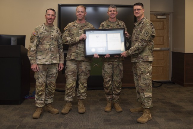 The President&#39;s Volunteer Service Award is presented to the command team of Company B, 787th Military Police Battalion – Capt. Thomas Robbins (center, left) and 1st Sgt. Clinton Morrison (center, right) – on behalf of the President by Col....