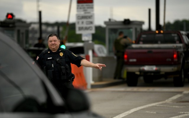 Redstone Police Deputy Chief Dennis Brown directs a driver to the inspection lane in front of Gate 9.