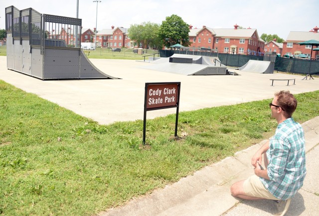 After taking a photo on his phone, U.S. Army Reserve 1st Lt. Patrick Clark, City of Leavenworth Parks and Recreation aquatics manager, pauses in front of the new skate park sign honoring his brother, Cody Clark, after a ceremony dedicating the...
