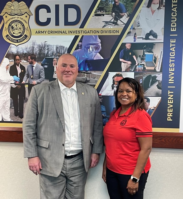 CID Director Gregory Ford and Army General Counsel Carrie Ricci stand in front of an Army CID sign.