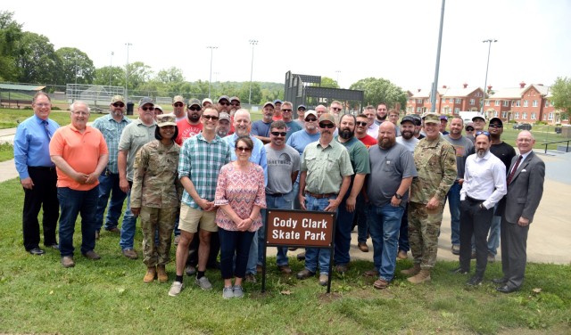 Fort Leavenworth, Kansas, Directorate of Public Works employees and Garrison staff join Cody Clark’s brother Patrick, mother Lori and father James for a photo by the sign dedicating the skate park in memory of the DPW employee who was killed in...
