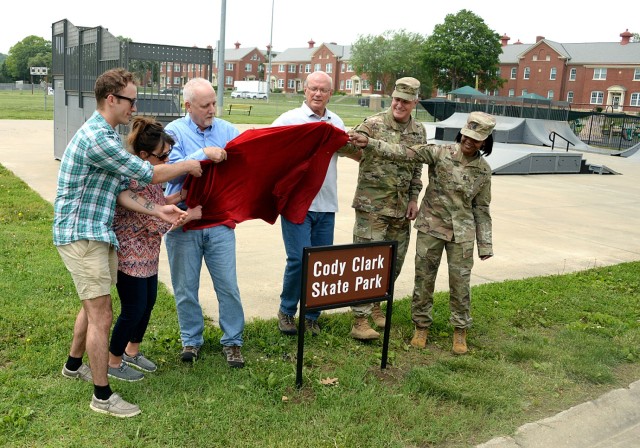 Cody Clark’s brother Patrick Clark, parents Lori Clark and James Clark, Directorate of Public Works Chief of Operations Jerry Clark, Garrison Commander Col. Duane Mosier and Garrison Command Sgt. Maj. Erika Rhine-Russell unveil the new sign...