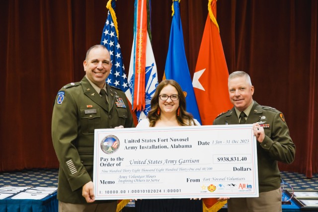 Rachael Cespedes, Army volunteer coordinator, presents a check representing the $938,831.40 in man hours that volunteers gave to the Fort Novosel community in 2023 to Maj. Gen. Michael C. McCurry, U.S. Army Aviation Center of Excellence and Fort...