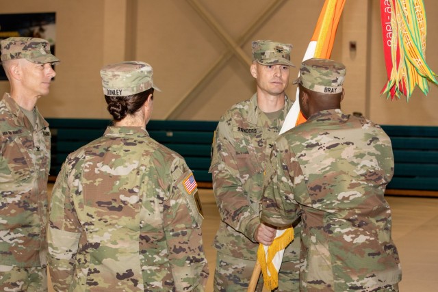 Incoming commander, COL John Sanders, passes the colors of the 21st Signal Brigade to CSM Thomas Bray, in a change of command ceremony on Ft. Detrick, 6 June 2024.