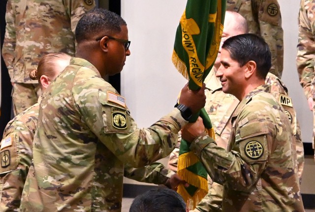 Outgoing Midwest Joint Regional Correctional Facility Battalion (Corrections) Commander Lt. Col. Byron Greene passes the colors to Army Corrections Brigade Commander Col. Kevin Payne during his change of command with incoming MWJRCF Battalion...