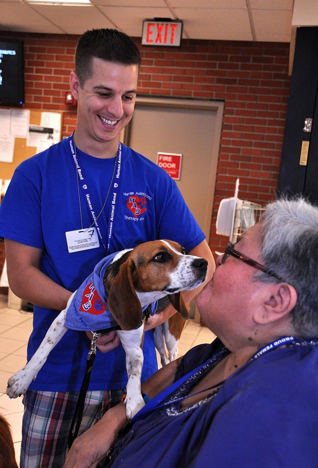 Fort Leavenworth Human Animal Bond volunteer Maj. Mike Centola holds his beagle Nickel as Linda Schneider, an Army veteran who served 1976-78 at Fort Polk, La., receives a few puppy kisses during a HAB visit with patients June 4, 2016, at the...