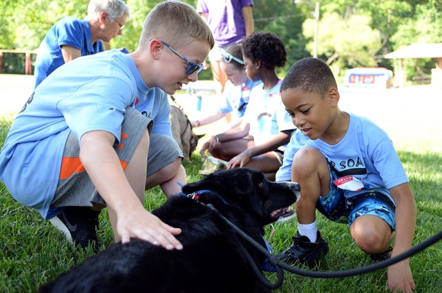 Ten-year-old Adam Gisler and 8-year-old A.J. Reynolds visit with Human Animal Bond member Marie Hansen's dog, Ace, at Camp Soar June 5, 2018, at Hunt Lodge on Fort Leavenworth, Kansas. Photo by Prudence Siebert/Fort Leavenworth Lamp
