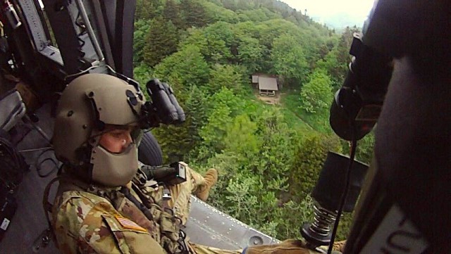 Tennessee Army National Guard Black Hawk helicopter crew chief Sgt. Daniel Bandy prepares to lower flight paramedic Sgt. 1st Class Giovanni DeZuani by hoist to rescue a hiker in cardiac distress at the Double Spring Gap Shelter in the Great Smoky...