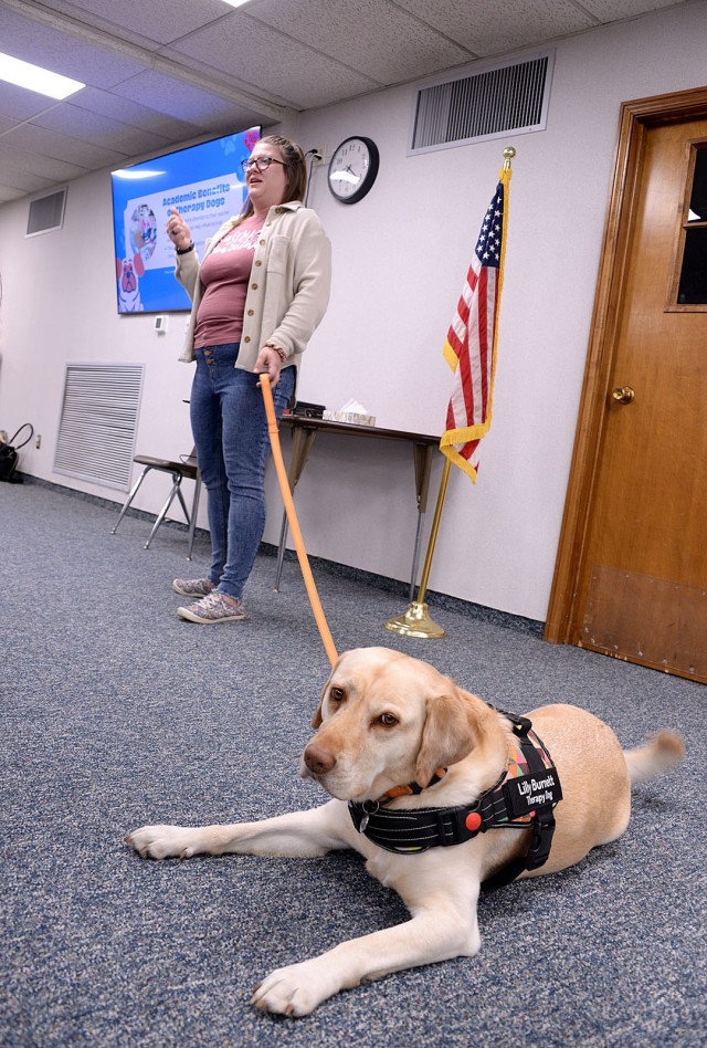 Fort Leavenworth Human Animal Bond member Shelby Burnett, social worker at Tonganoxie Elementary School, and Lilly, her 4-year-old Dutch retriever, talks to HAB members about why they do pet therapy and the impact they have during a presentation...