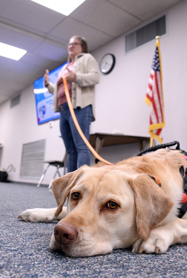 Fort Leavenworth Human Animal Bond member Shelby Burnett, social worker at Tonganoxie Elementary School, and Lilly, her 4-year-old Dutch retriever, talks to HAB members about why they do pet therapy and the impact they have during a presentation...
