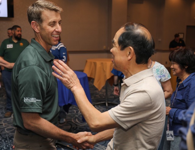 Col. Marcus Hunter, left, commander of U.S. Army Garrison Japan, shakes hands with a member of the Japan-America Society of Central Kanagawa during a “State Day” event at Camp Zama, Japan, June 20, 2024. Hunter and Command Sgt. Maj. David A. Rio, garrison senior enlisted leader, shared details and food items from their respective home states of Virginia and Indiana as part of the cultural exchange.