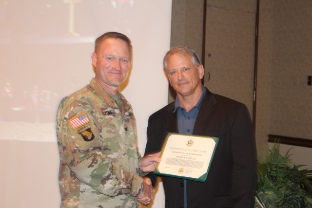 Garrison Commander Col. Brian Cozine presents a certificate of retirement June 26 to Derrick Gould, director of Family and Morale, Welfare and Recreation, as Gould culminates 37 years of service in MWR, the past 19 years at Redstone. “It’s not...