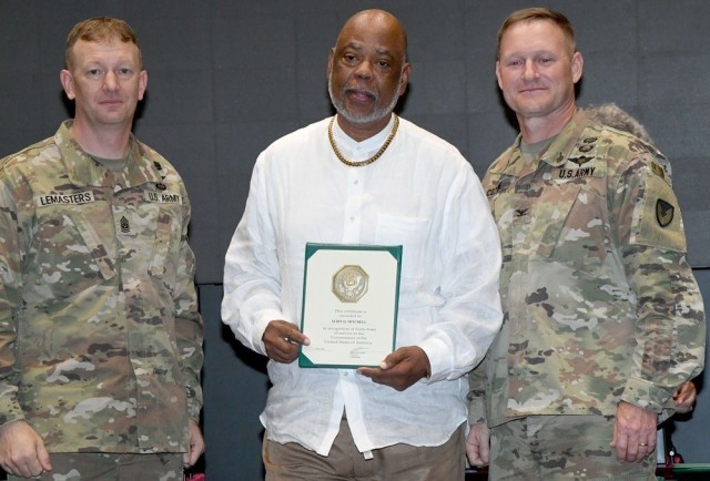 Aldin Mitchell receives a 40-year service award from Command Sgt. Maj. Dylan Lemasters and Garrison Commander Col. Brian Cozine.